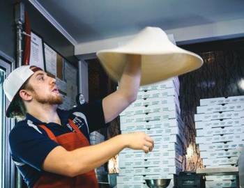 Man spinning a pizza.