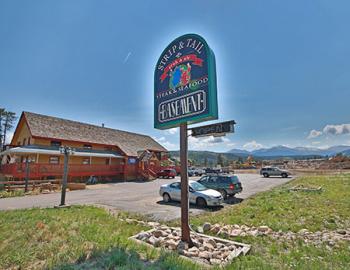 Basement restaurant exterior. Sign text: Strip & Tail, Crab & Ale, Steak & Seafood, Basement.