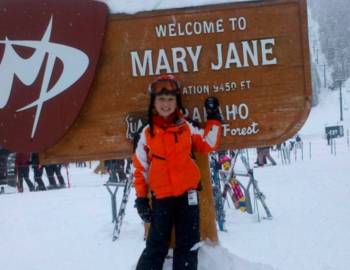 Woman posing at Mary Jane sign. Text: Welcome to Mary Jane.