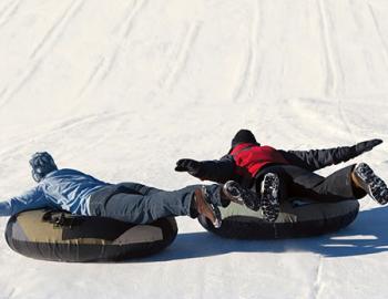 Adults laying on snowtubes.