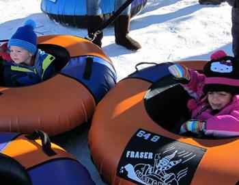 Little kids in snow inner tubes.