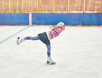Young woman skating on one leg.