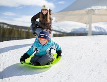 Boy sledding downhill.